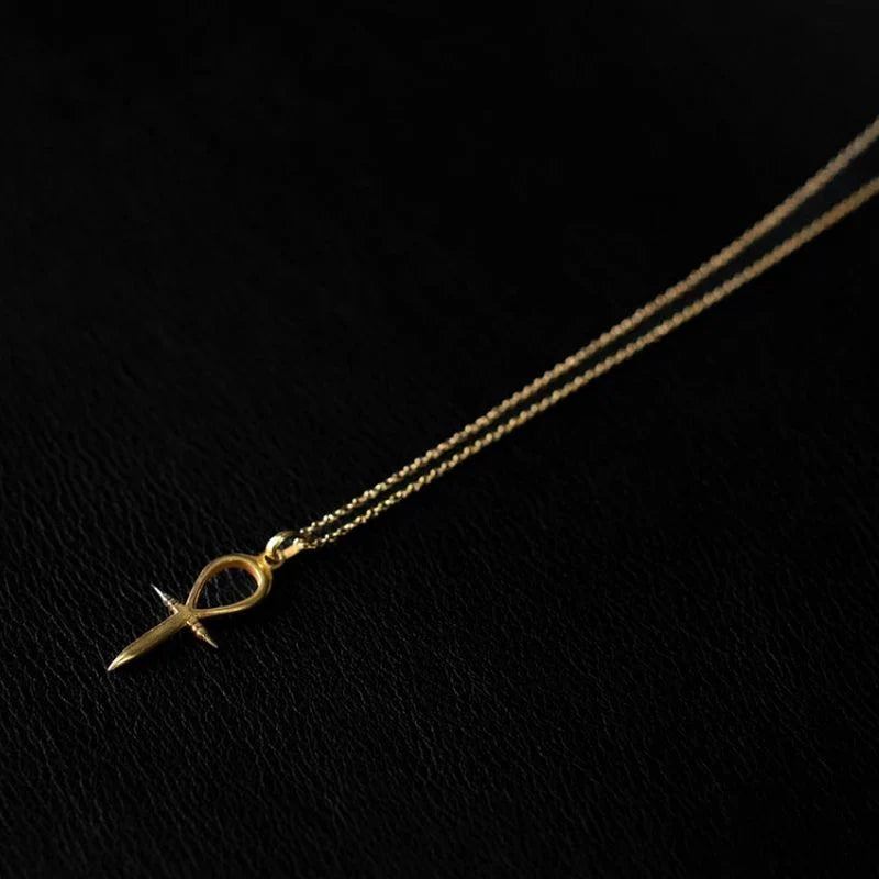 Ankh pendant necklace in 22K gold vermeil over 925 sterling silver on a delicate chain, resting at the collarbone against bare skin.