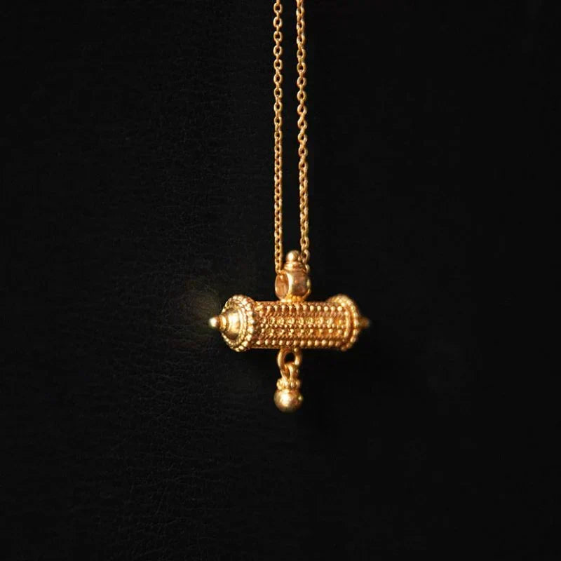 22K gold plated over 925 sterling silver barrel amulet charm necklace with beaded detail and bell, worn as a protective symbolic object on a fine chain.