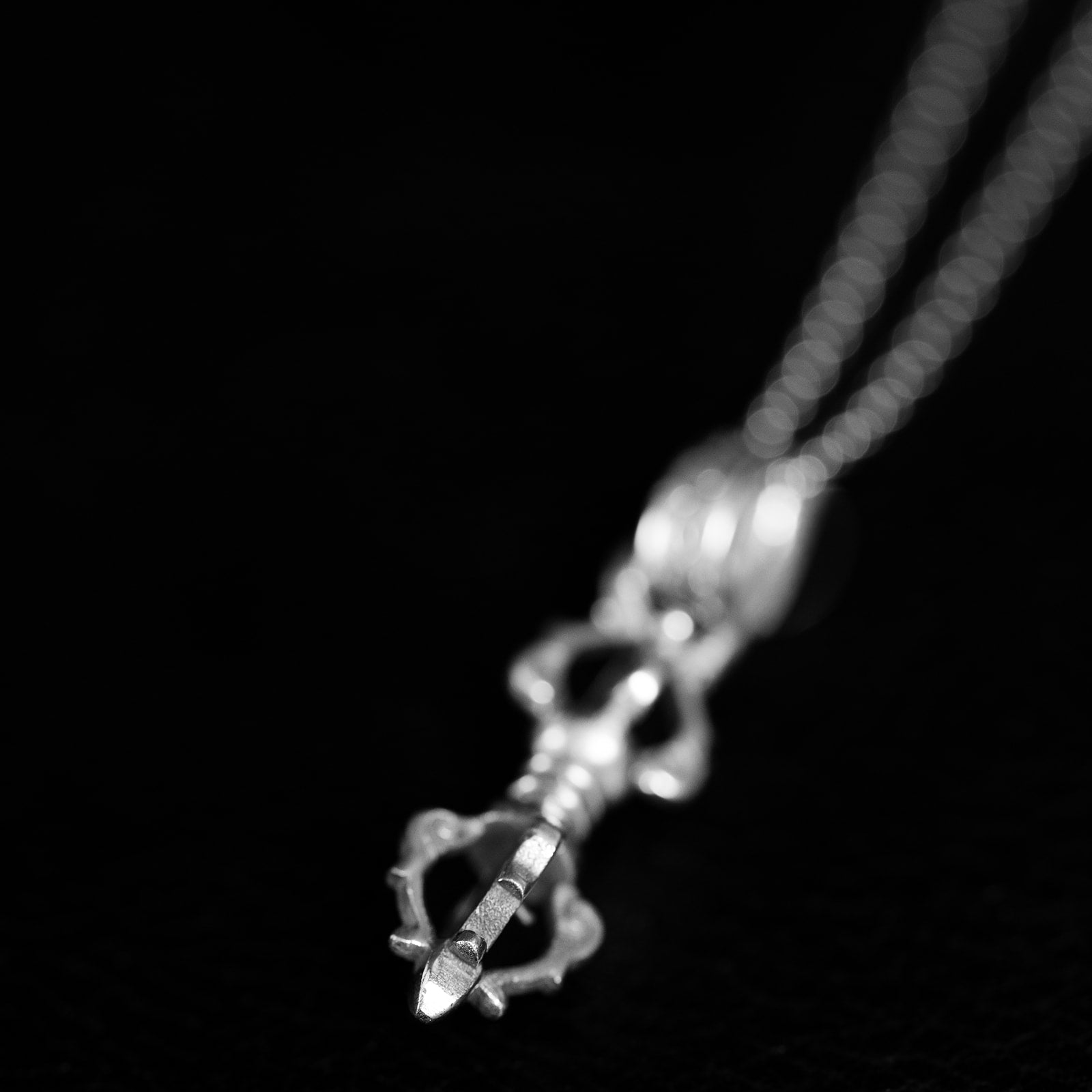 925 sterling silver vajra pendant, a symmetrical double-headed thunderbolt form with curved prongs, on a fine chain.